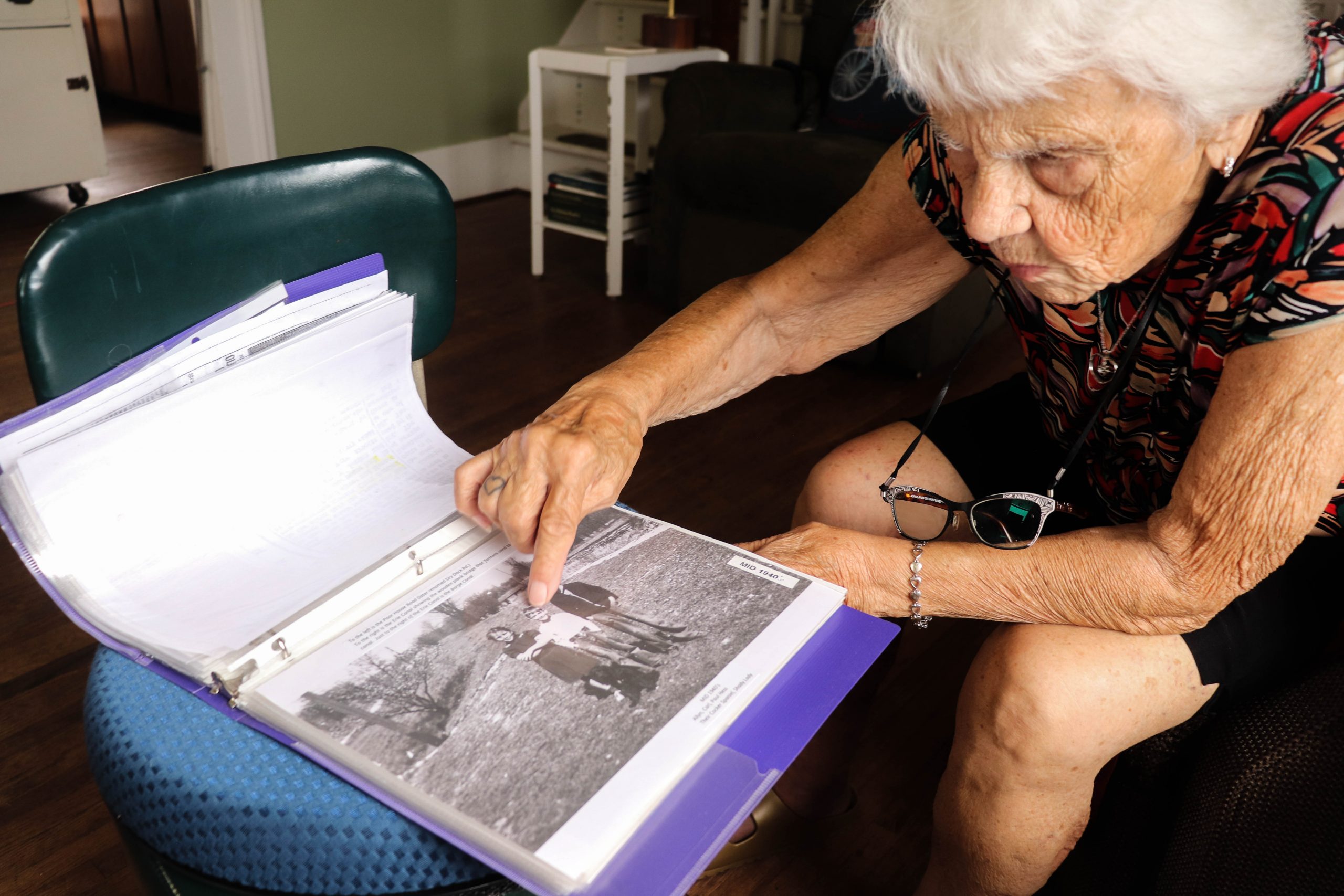 Allyn Perry points out a 1960 picture in a family photo album of her and her two brothers standing along the Erie Canal towpath in the backyard of her lifelong home on Dry Dock Road