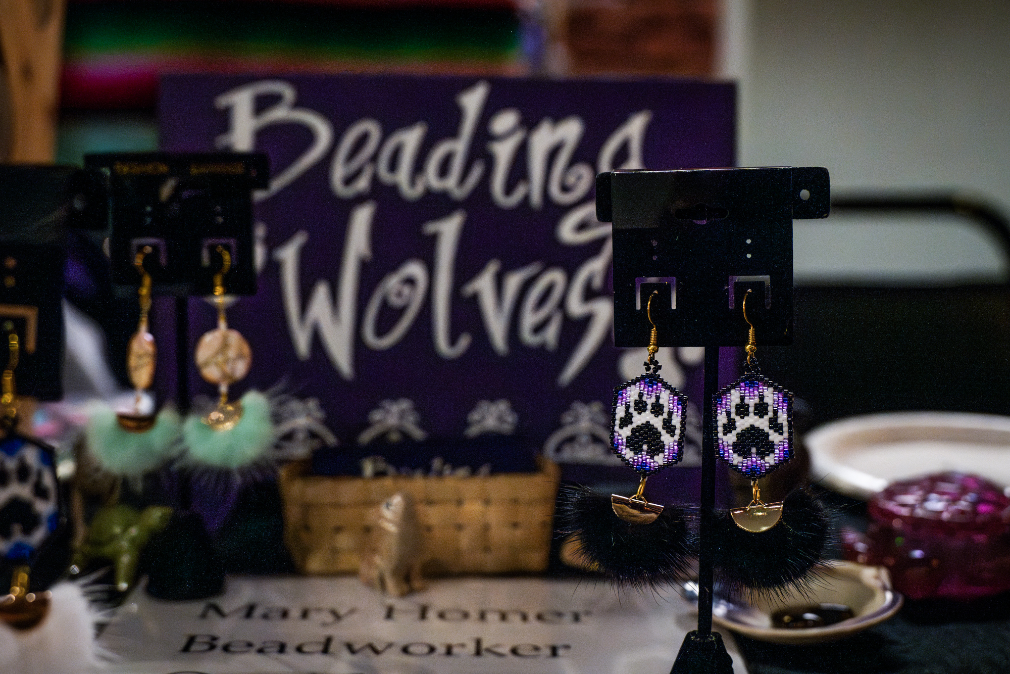 A pair of purple earrings sits at Mary Homer's craft stall, representing just some of the work Homer produces for her business, Beading Wolves. The color is symbolic of Iroquois history and their flag.
