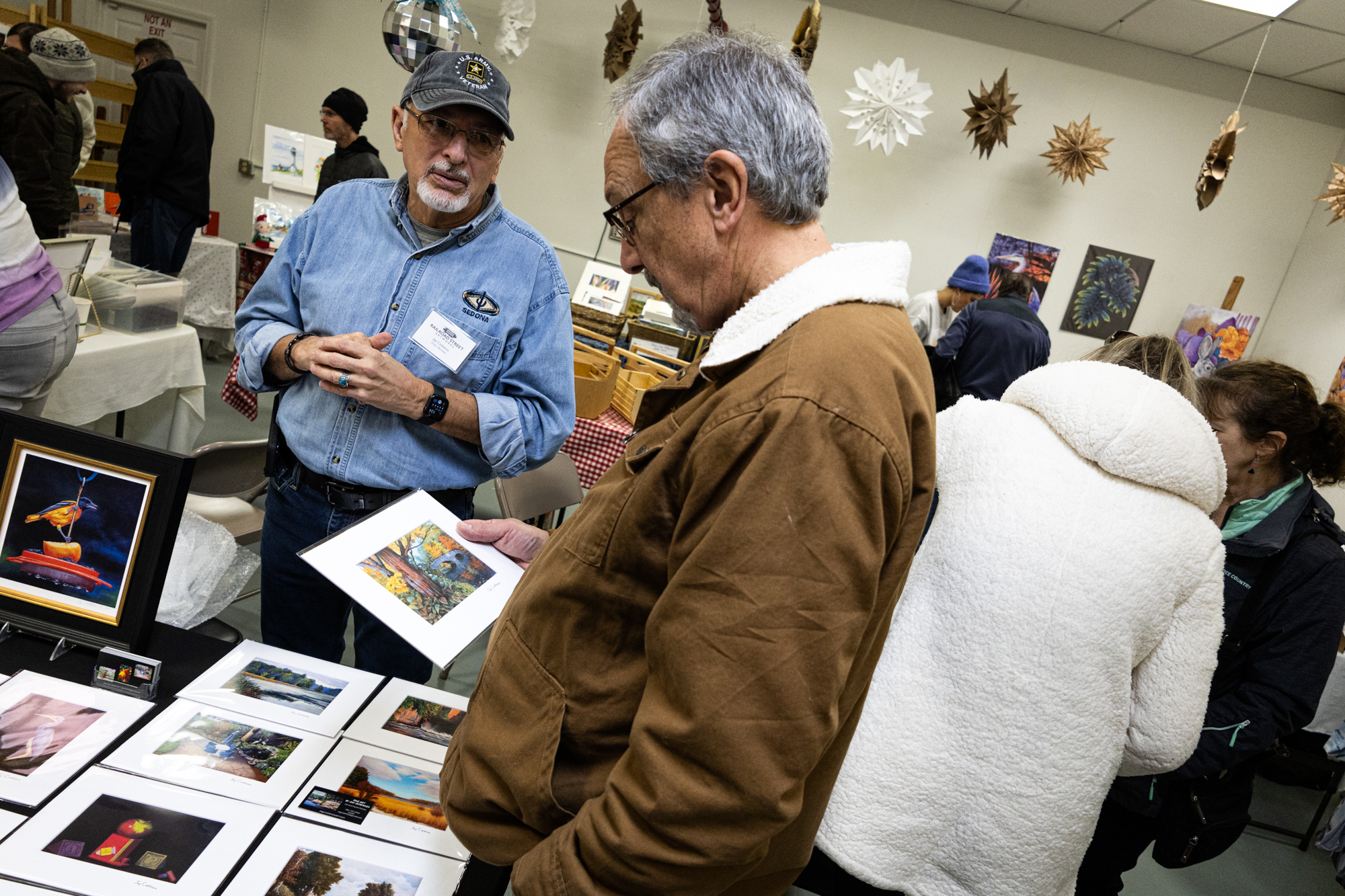 Jay Costanza, an oil and pastel painter, discusses his art with a potential customer.